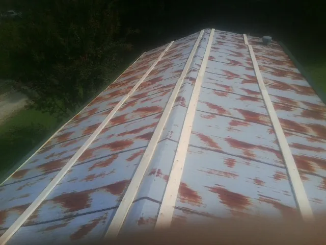 Rusted metal roof panels with new wood purlins before replacement — Storm Damage Roof Repair in Ethridge by Roofing Brothers