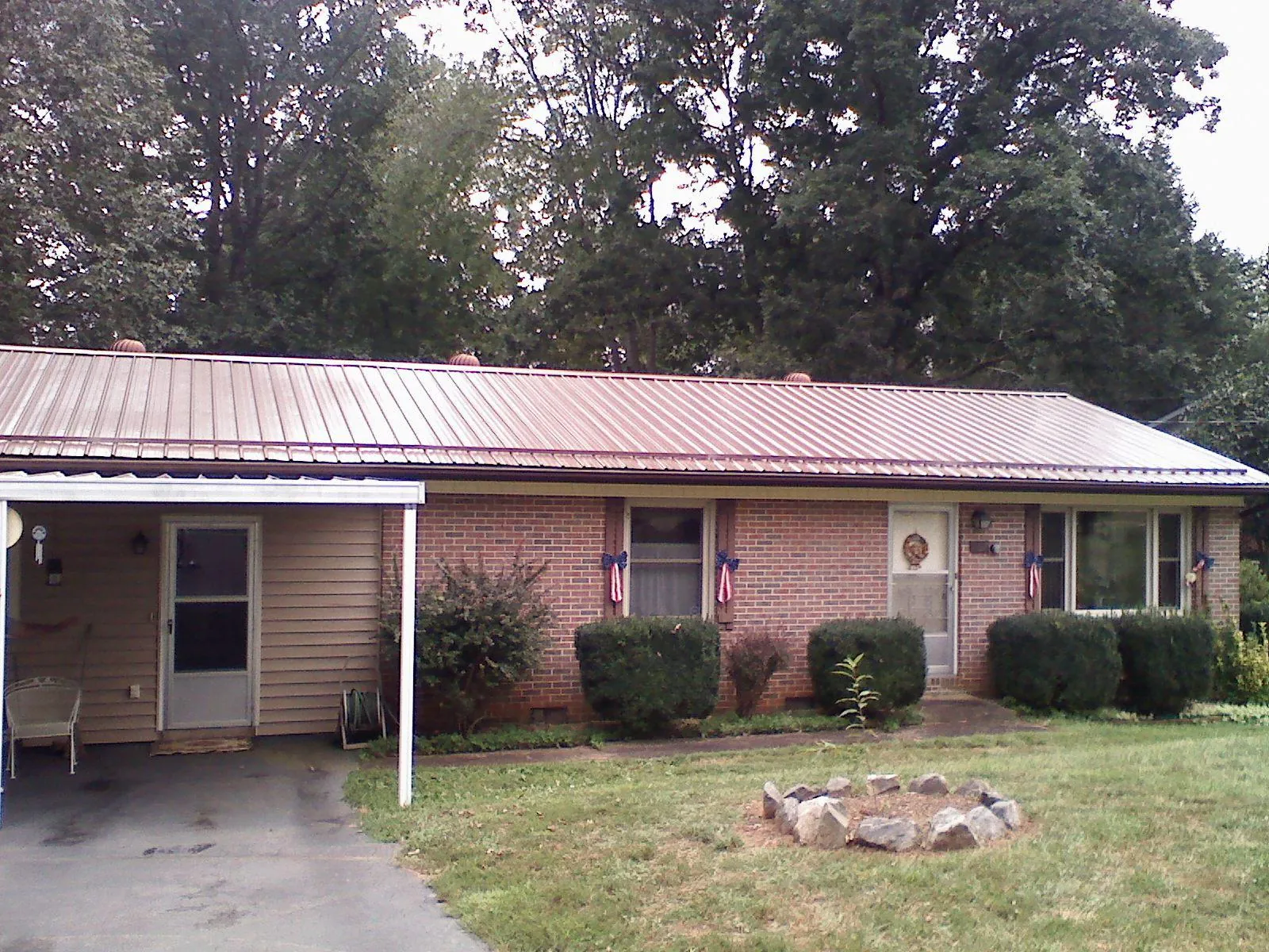Bronze metal roof and carport on a brick ranch home — Roof Repair work by our crew in Ethridge
