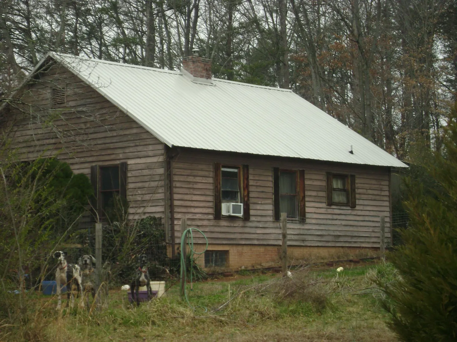 White metal roof on an old wood sided farmhouse, from a Metal Roof Installation job in Ethridge